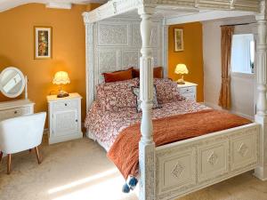 a bedroom with a large bed with orange walls at Bank Top Cottage - Uk49215 in Wilsden