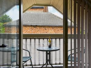 a table with a bottle of wine on a balcony at The Hayloft in Hunstanton