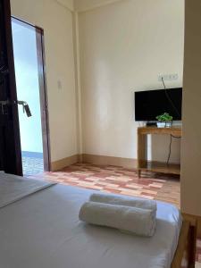 a bedroom with a bed with a television and a table at Bocala Beach Resort in Balud