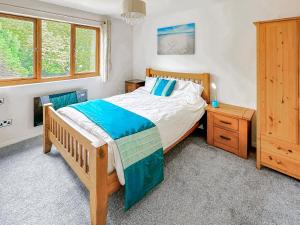 a bedroom with a wooden bed and a wooden dresser at Spring Vale Bungalow in Colchester +15 photos