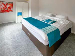 a bedroom with a large bed with blue and white sheets at Spring Vale Bungalow in Colchester