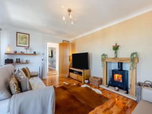 a living room with a fireplace and a tv at Baobab Lodge in Prestatyn