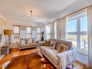 a living room with a couch and chairs and windows at Baobab Lodge in Prestatyn