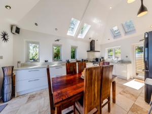 a kitchen with white cabinets and a wooden table at Baobab Lodge in Prestatyn +26 photos
