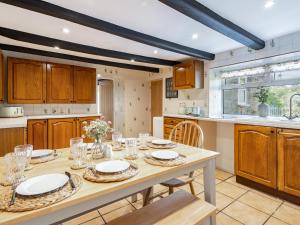 a kitchen with a wooden table with plates on it at Rigg Farm Cottage in Stainsacre +16 photos