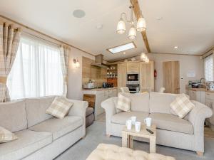 a living room with two couches and a kitchen at Bay View 34 in Weymouth