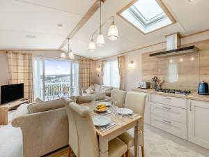 a kitchen and living room with a table and a couch at Bay View 34 in Weymouth +11 photos