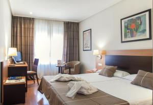um quarto de hotel com duas camas e uma televisão em FC Infantas de León em León