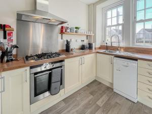 a kitchen with white cabinets and a stove top oven at Murray Street Town House in Duns