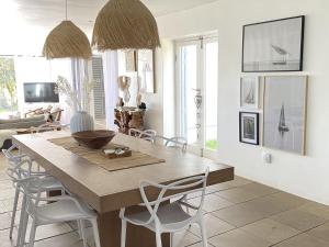 a dining room with a wooden table and chairs at Namaste - Sea-facing 4 sleeper Holiday Home in Paternoster