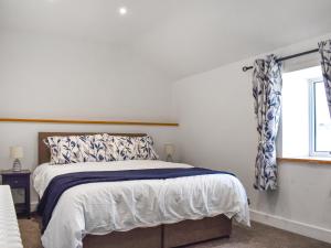 a white bedroom with a bed and a window at Lavender Cottage -Uk49209 in Jacobstowe +7 photos