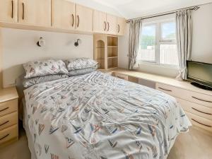 ein Schlafzimmer mit Bett und Flachbildfernseher in der Unterkunft The Lodge in Chapel Saint Leonards