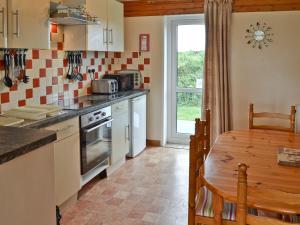 a kitchen with a table and a dining room at Brambles in St. Agnes 