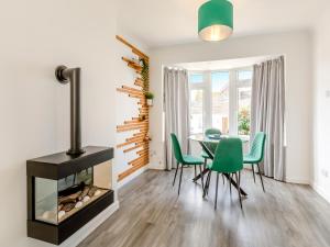 a dining room with a fireplace and a table and chairs at Driftwood Villa in Brixham