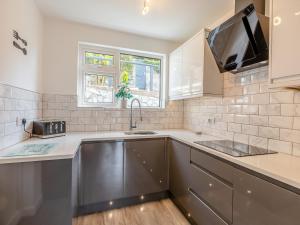 a kitchen with a sink and a microwave at Driftwood Villa in Brixham +11 photos
