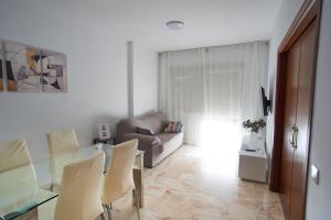 a living room with a couch and a table and chairs at Apartamento con piscina solo en temporada in Seville