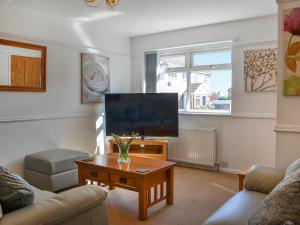 a living room with a tv and a coffee table at Swan's Nest in Filey