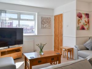 a living room with a couch and a tv at Swan's Nest in Filey