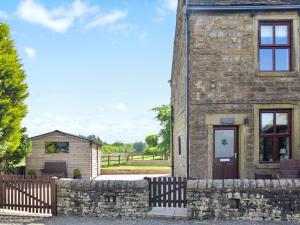 a stone house with a gate and a fence at Doorstones Cottage in Moorside