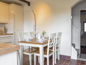 a kitchen with a table and chairs in a room at Doorstones Cottage in Moorside