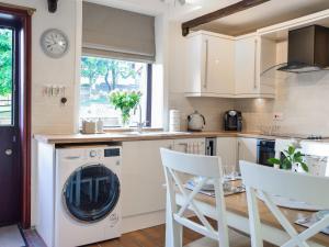 a kitchen with a washer and dryer at Doorstones Cottage in Moorside