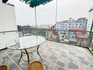 a glass table and chairs on a balcony with a view at Eco Hotel Tran Hung Dao - Old Quater in Hanoi +14 photos
