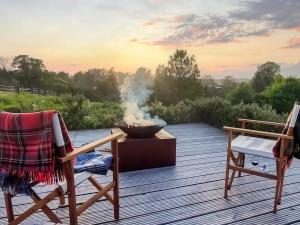a deck with two chairs and a fire pit at Tower Cottage - Uk49339 in Whittingham