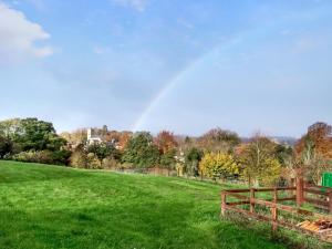 a rainbow in the sky over a field with a fence at Tower Cottage - Uk49339 in Whittingham