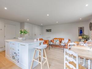 a kitchen and living room with a counter and chairs at Moat Farm in Tring