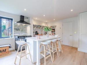 a kitchen with a large white island with bar stools at Moat Farm in Tring