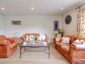 a living room with leather couches and a coffee table at Moat Farm in Tring
