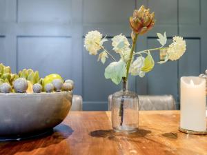 a vase with flowers and a bowl of fruit on a table at Moat Farm in Tring +25 photos