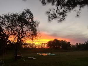 ein Drachen auf einem Feld mit einem Sonnenuntergang im Hintergrund in der Unterkunft Tierra De Artes in Vuelta de Obligado + 4 Fotos