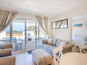 ein Wohnzimmer mit Sofa und Tisch in der Unterkunft 5 Curlew, The Cove in Brixham