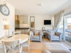 eine Küche und ein Wohnzimmer mit Tisch und Stühlen in der Unterkunft 5 Curlew, The Cove in Brixham + 11 Fotos