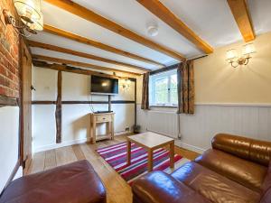 a living room with a couch and a tv at Poona Cottage in Cadnam