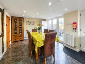 a dining room with a yellow table and chairs at Poona Cottage in Cadnam +21 photos