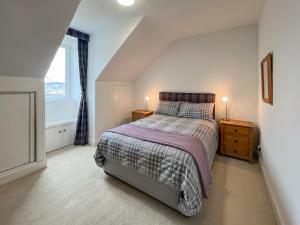 a small bedroom with a bed and a window at Glengilp Apartment - Uk49317 in Ardrishaig