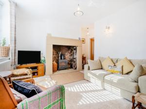 a living room with a couch and a fireplace at Nook Cottage in Durham