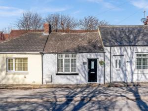 a white house with a black roof at Nook Cottage in Durham