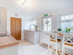 a kitchen with white walls and a wooden door at Nook Cottage in Durham +13 photos