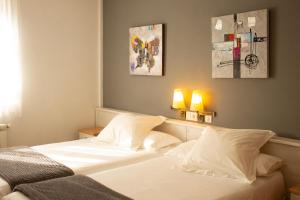 a bedroom with a large white bed with two lamps at Hotel La Casa Del Abuelo in Tapia de Casariego