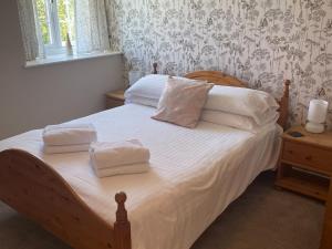 a bedroom with a bed with white sheets and pillows at Goldfinch Apartment - Uk49296 in Woolfardisworthy