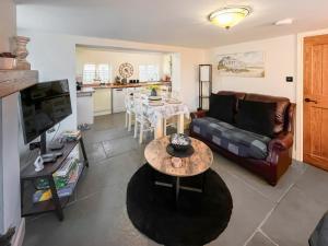 a living room with a couch and a table at Butterfly Cottage in Maltby le Marsh