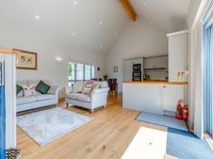 a living room with a couch and a kitchen at Lavender Barn in Heacham