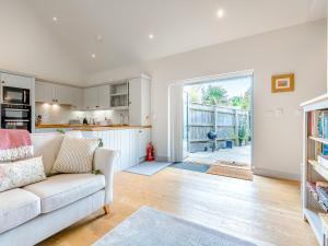 a living room with a couch and a kitchen at Lavender Barn in Heacham