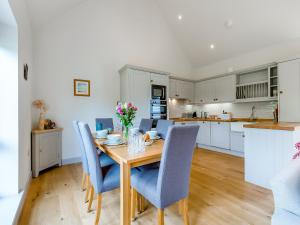 a kitchen and dining room with a wooden table and chairs at Lavender Barn in Heacham