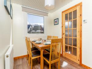 a dining room with a table and chairs and a window at Walled Cottage - Uk49097 in Inchnadamph +15 photos