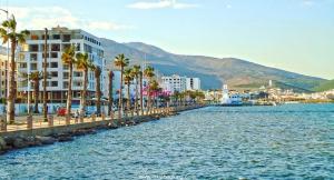 a body of water with palm trees and a building at Nador city corniche - Famille - in Nador