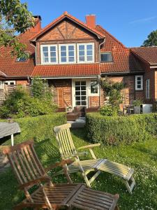 two chairs sitting in the grass in front of a house at Romantic house in charming village in Schashagen